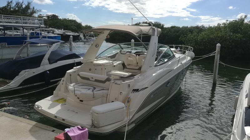 Cockpit of the Monterey sport yacht docked in a Cancun marina, tan upholstery and bimini, set for sunset cruises to Isla Mujeres