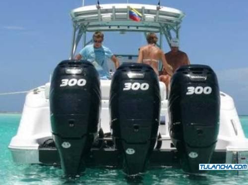 Triple 300 HP outboard engines on Donzi powerboat stern showing massive 900 HP total for Caribbean fishing charter tours