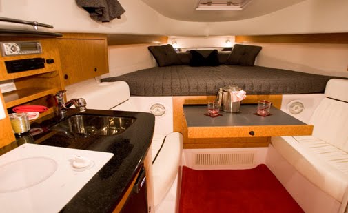 Interior cabin of Donzi 38 sport yacht with sleeping berth, full kitchen and dining area for luxury Cancun rentals