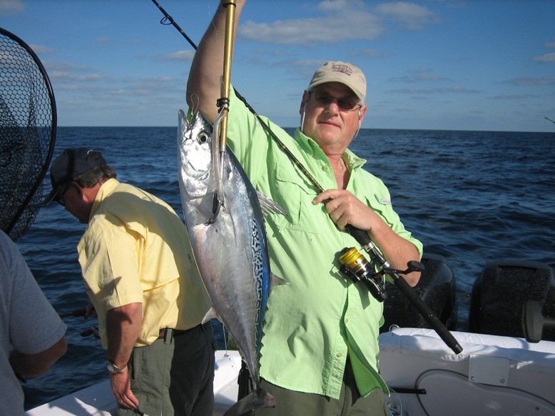 Angler proudly holding large Caribbean tuna fish caught on sport fishing charter tour from Cancun aboard the Donzi 38