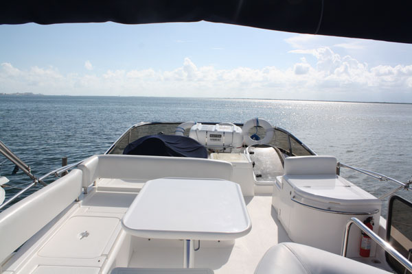 Forward cockpit deck view from Sunseeker 58 ft charter yacht showing seating table and open Caribbean horizon under blue sky