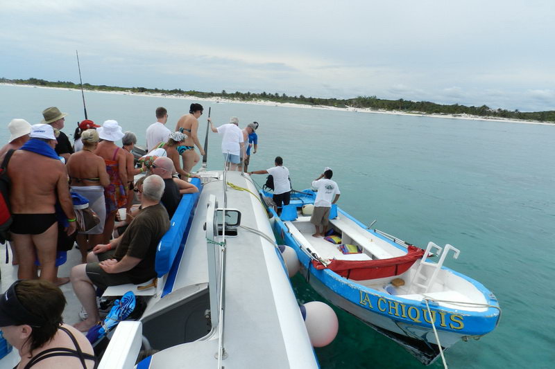 Buffet lunch service aboard Raiatea group catamaran during sailing day tour to Tulum ruins Riviera Maya