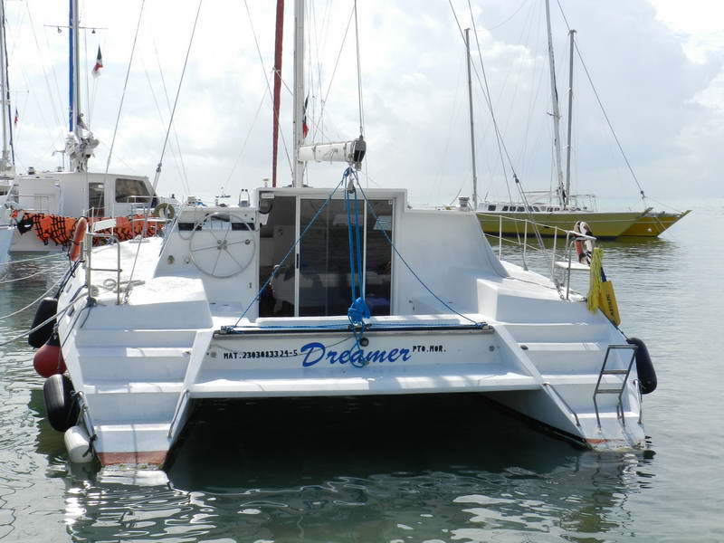 Dreamer catamaran at anchor near the turquoise reef of Marina Maroma on the Riviera Maya, private group charter rental