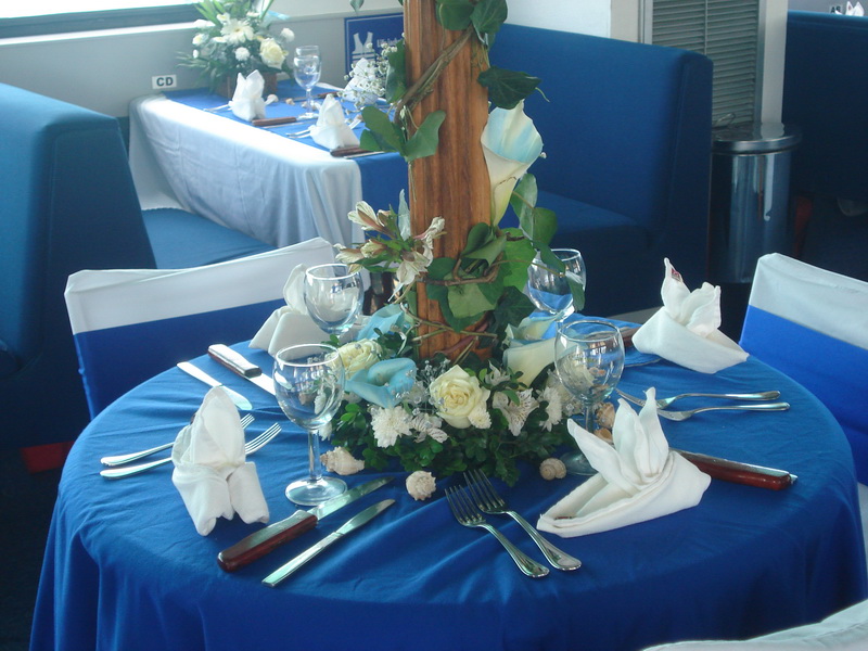 Close-up of a Discovery wedding table with blue linen, calla-lily centerpiece, wine glasses and folded napkins