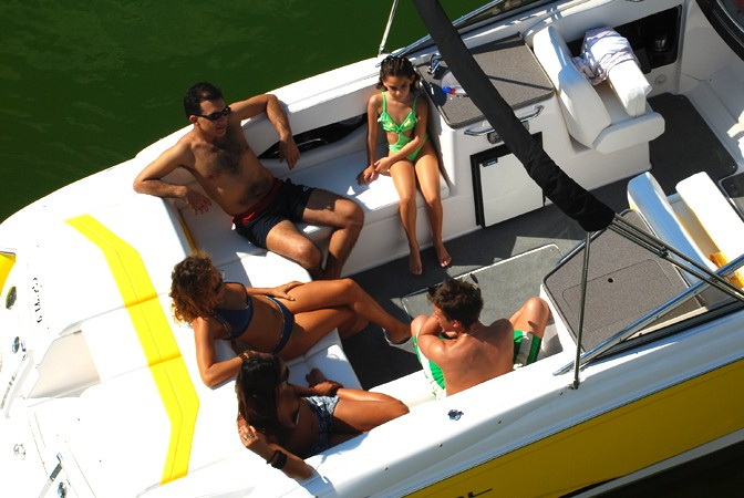 Aerial view of group relaxing on deck of yellow Regal 27 ft sport boat at Puerto Aventuras marina private charter Riviera Maya